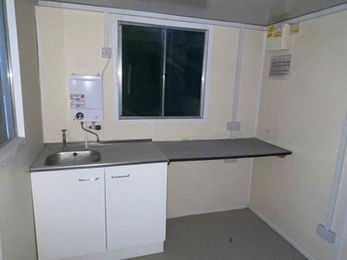Internal view of cabin, with sink, sideboard and storage